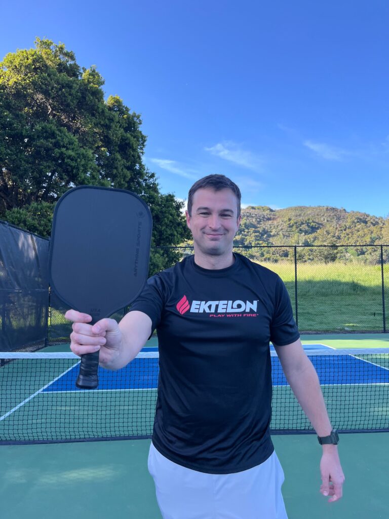 Picture of man holding the Anything Sports pickleball paddle.