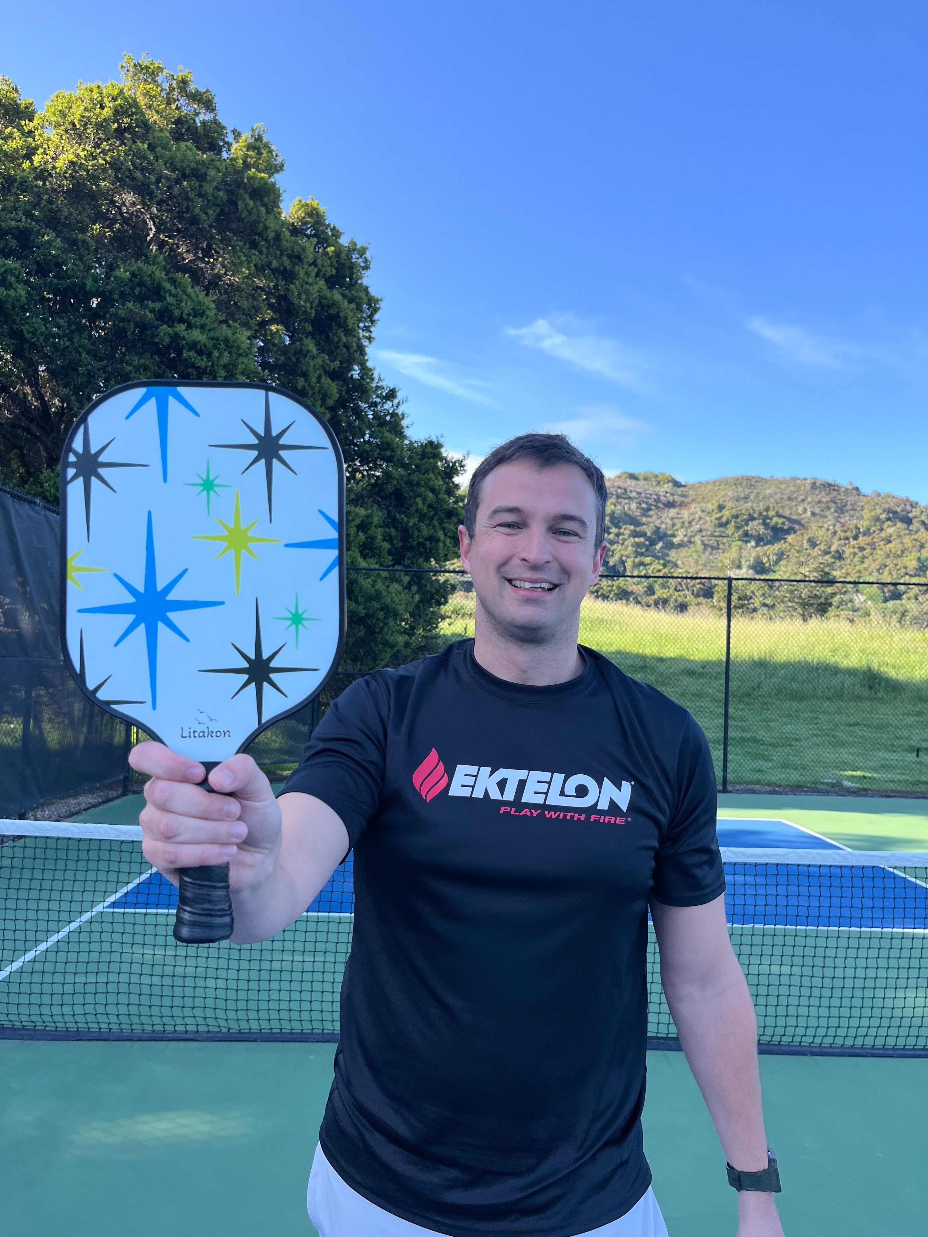 Picture of man holding beginner pickleball paddle.