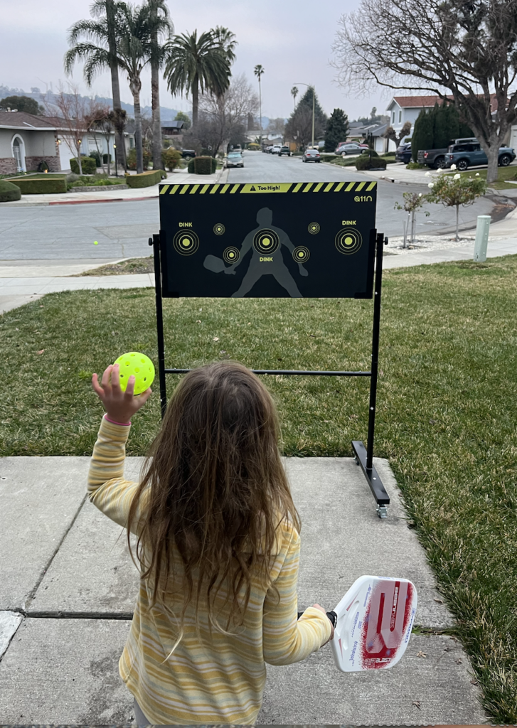 Picture of kid playing with a rebounder board for a pickleball drill.