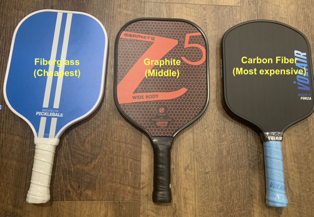 Picture of 3 different pickleball paddles that consider of fiberglass, graphite, and carbon fiber.