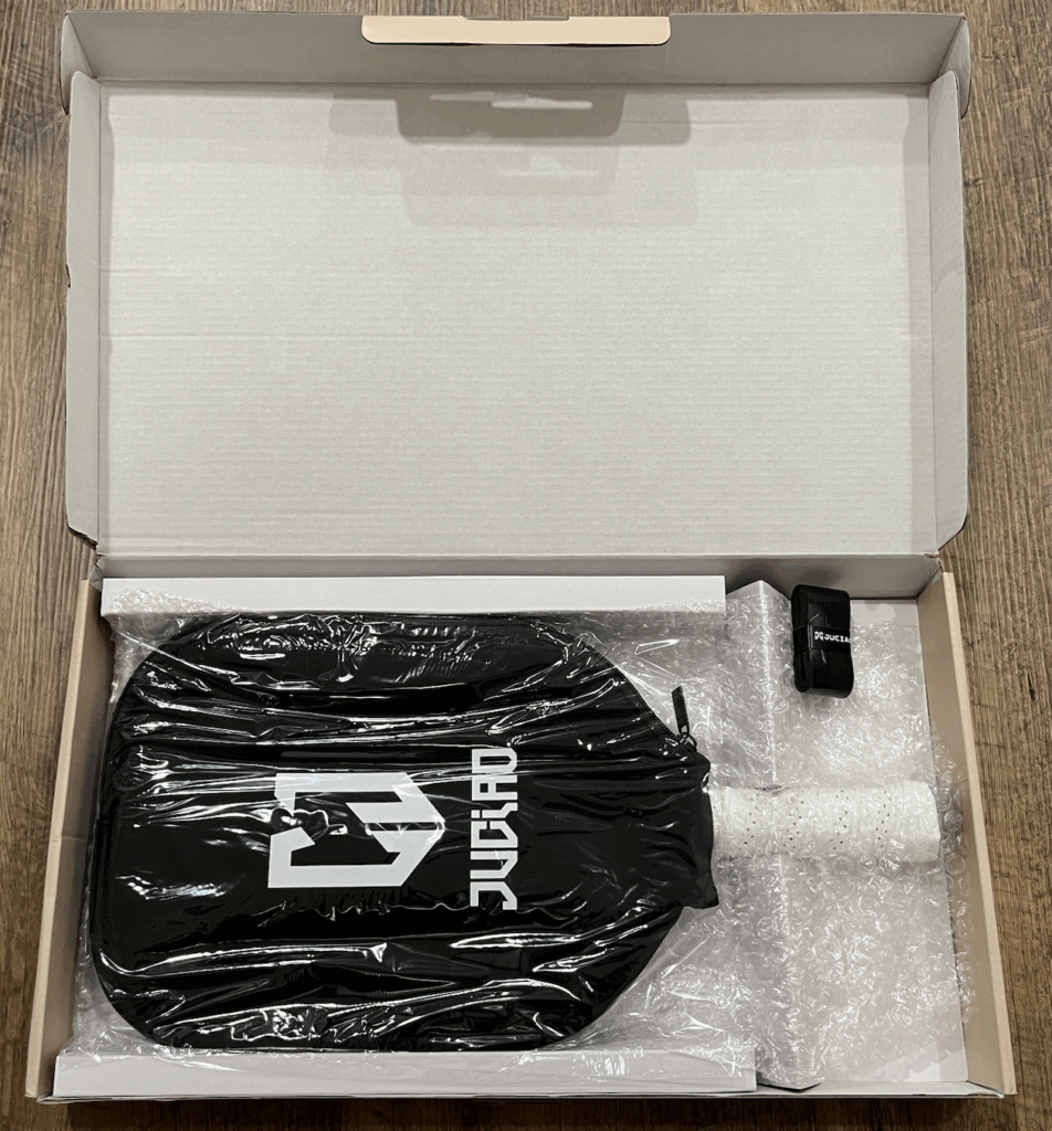 Picture of the Juciao pickleball paddle box with the paddle cover and grip tape.