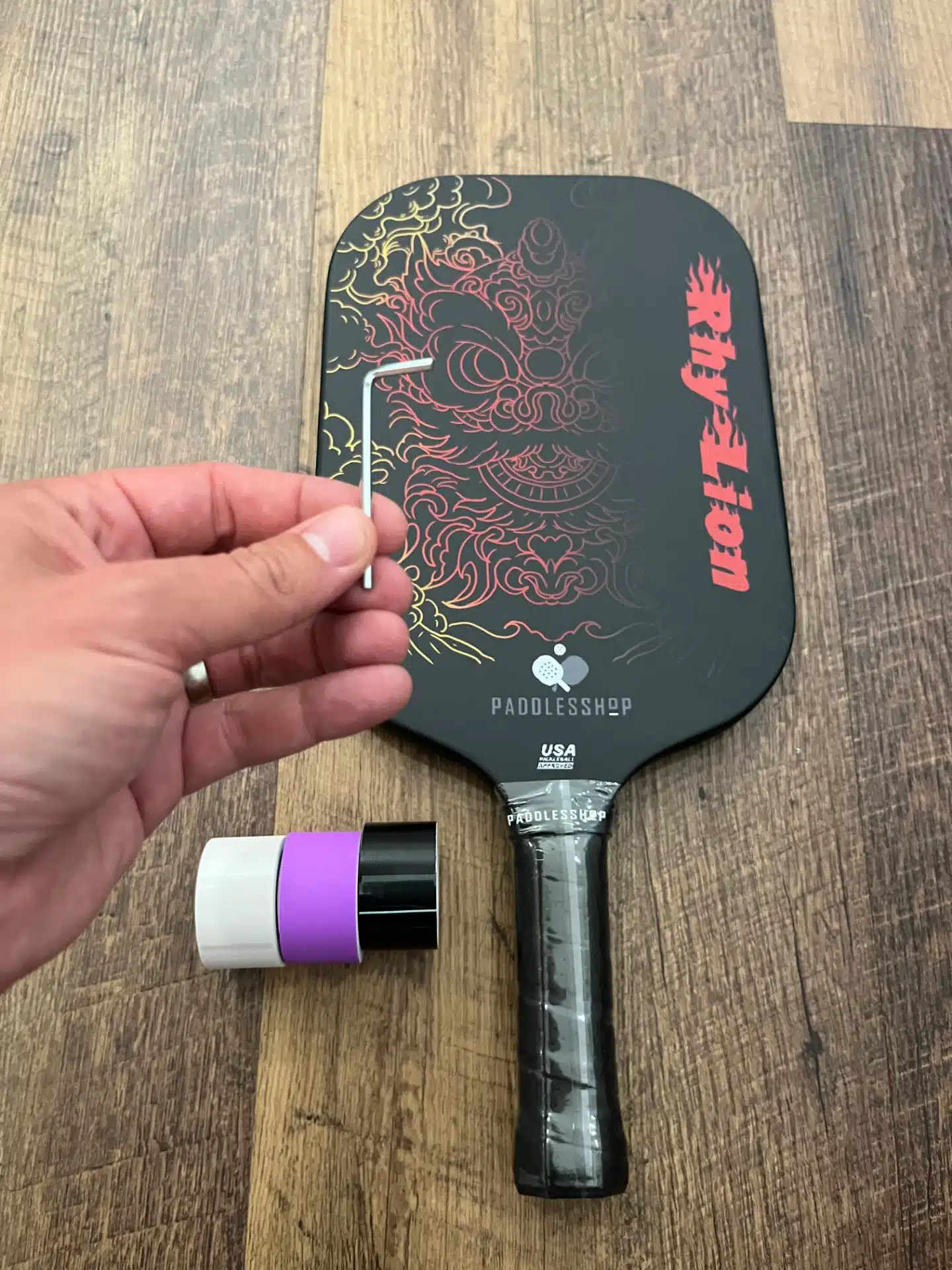 Close up picture of a tool and the Paddlesshop Rhylion pickleball paddle.